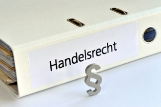 Ordner mit Aufschrift Handelsrecht und Paragraphen-Symbol